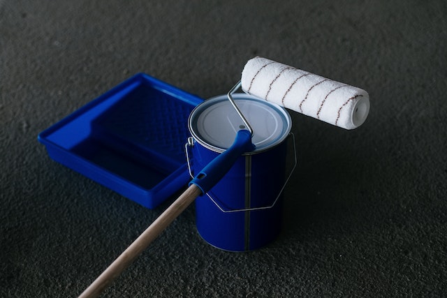 blue paint tray and can with a clean roller on top