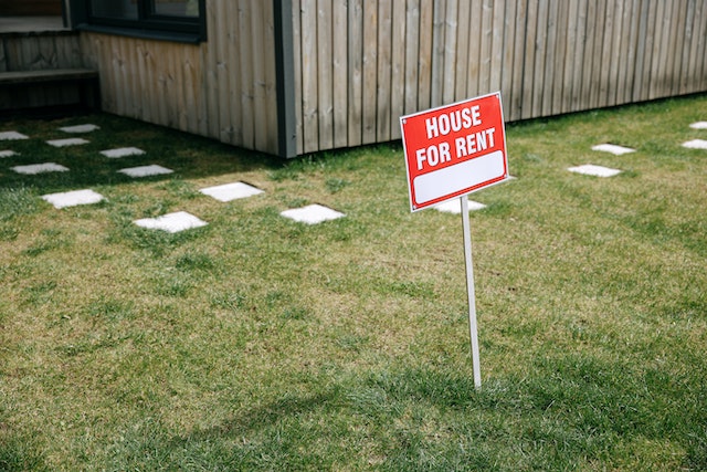a red yard sign indicating a home for rent